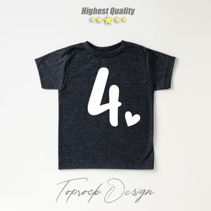K&ouml;nnte beinhalten: Ein dunkelgraues T-Shirt mit einer wei&szlig;en Zahl "4" und einem kleinen Herz auf der Vorderseite. Das Shirt ist aus einem weichen, bequemen Material.