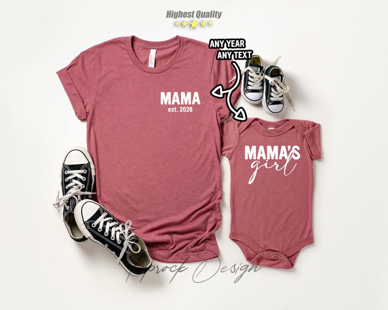May include: A matching set of maroon shirts and a baby bodysuit. The adult shirt has "MAMA est. 2026" printed on the front. The baby bodysuit says "MAMA'S girl". Black and white sneakers are placed near the shirts.