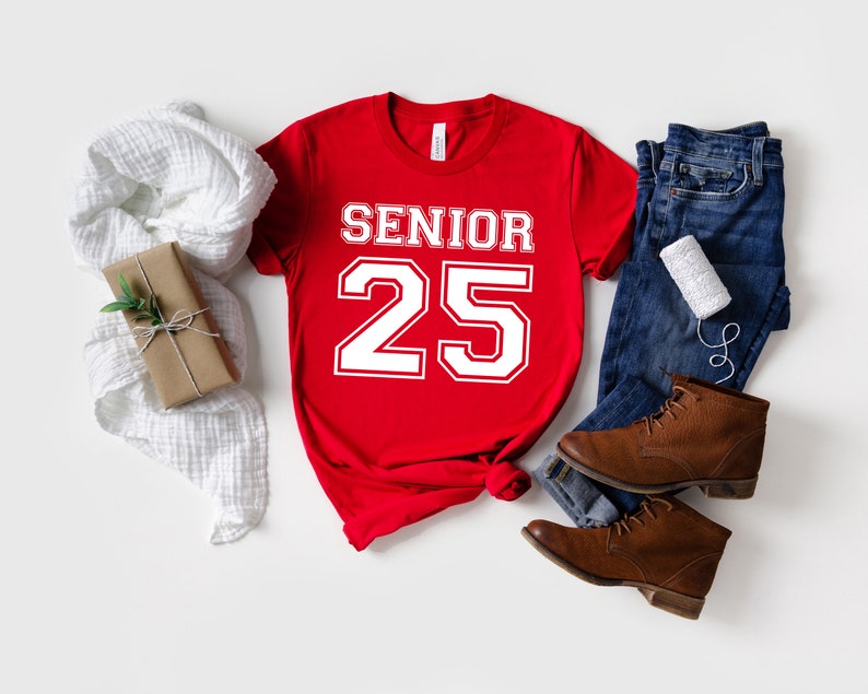 May include: Red t-shirt with white text that says "Senior 25" in a varsity style font.