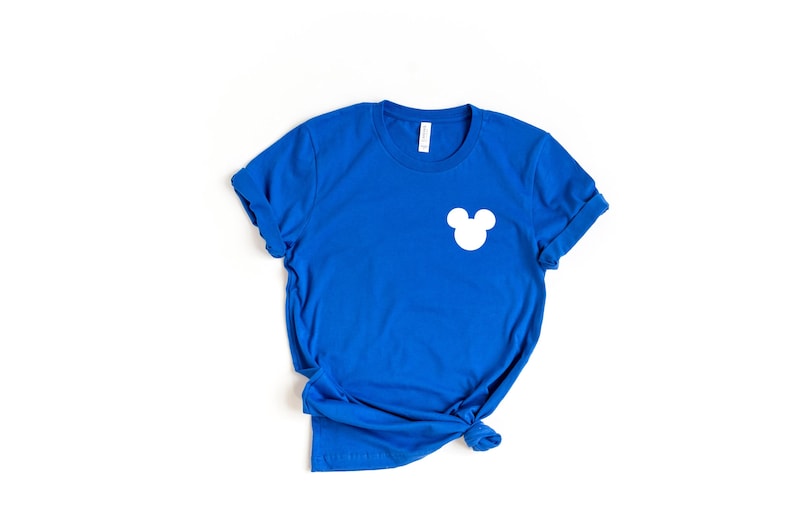 Puede incluir: Una camiseta azul real con una silueta blanca de Mickey Mouse en el pecho izquierdo.