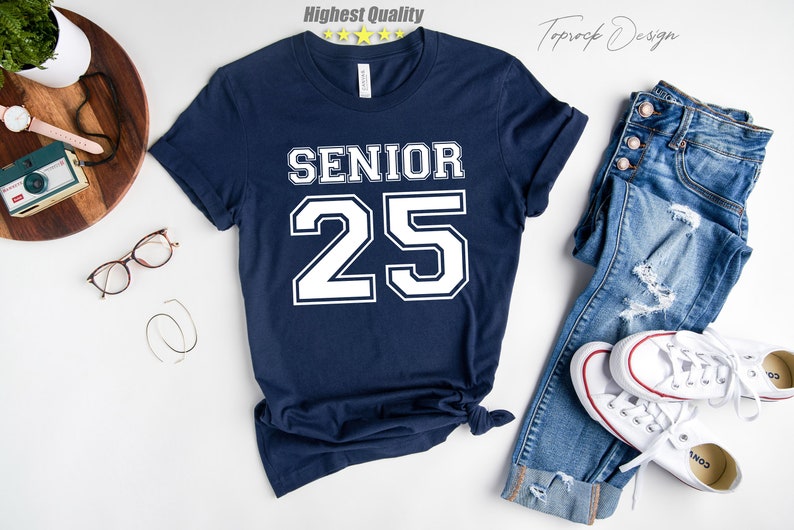 May include: A navy blue t-shirt with white text that says "Senior 25" in a varsity style font.