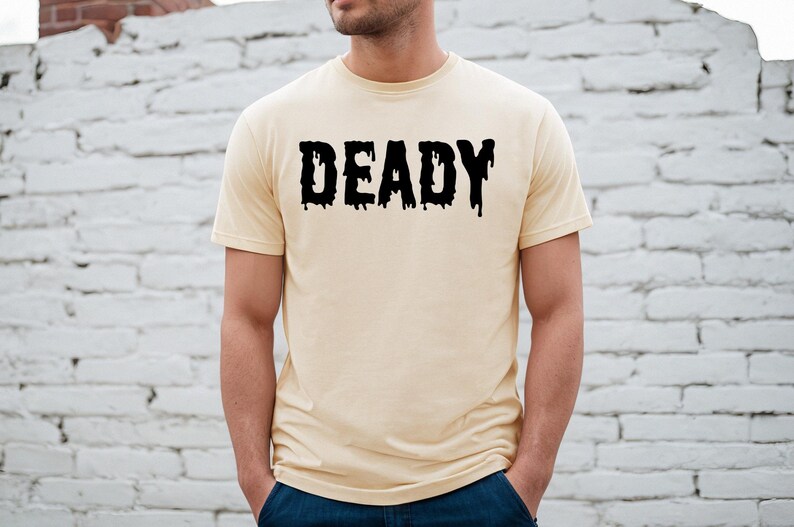 May include: A light beige t-shirt with a black graphic that says "DEADLY" in dripping letters.