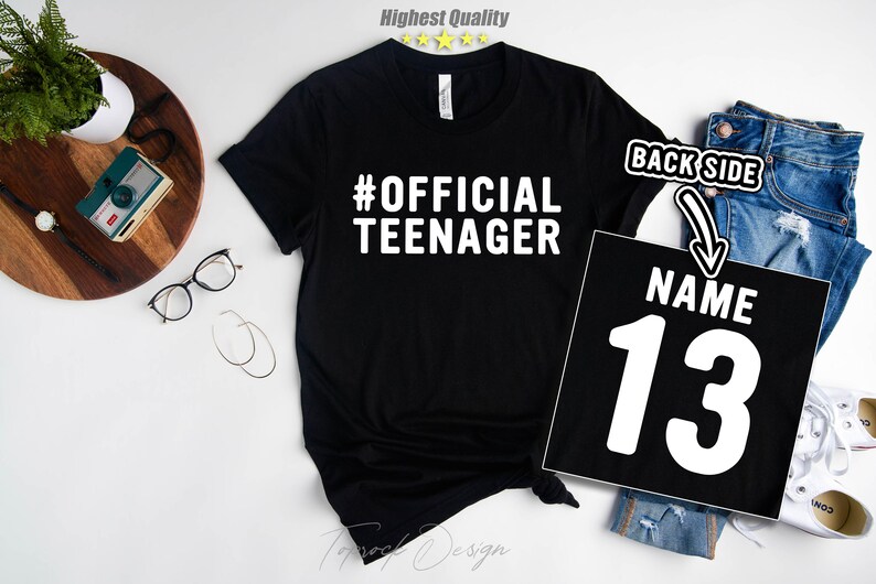 May include: Black t-shirt with white text that says "#OFFICIAL TEENAGER". The back of the shirt has a white number "13" with the word "NAME" above it.