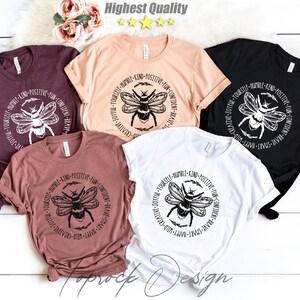 May include: Five different color t-shirts with a black and white bee graphic and the text "Treat Yourself - Humble - Kind - Positive - Fun - Confident - Brave - Smart - Happy - Creative - Joyful -  " printed on the front.