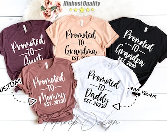 May include: Five t-shirts with the text "Promoted to" followed by different titles, such as "Aunt", "Grandma", "Grandpa", "Mommy", and "Daddy". Each shirt has a different color and the text is in white.