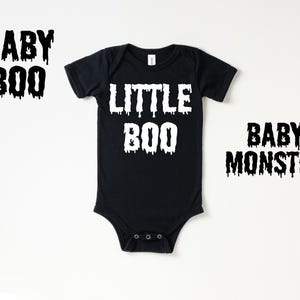 May include: Black bodysuit with white text that reads "Little Boo" on a white background.  Two additional images show the text "Baby Boo" and "Baby Monster" in black.