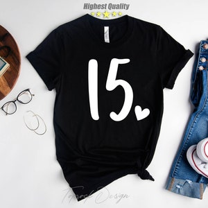 May include: Black t-shirt with the number "15" and a small white heart printed on the front.