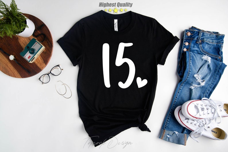 May include: Black t-shirt with the number "15" and a small white heart printed on the front.