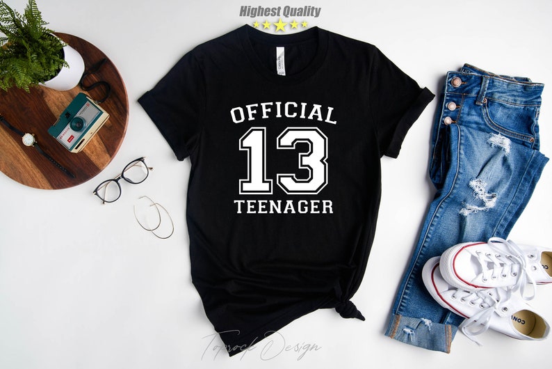 May include: Black t-shirt with white text that says "OFFICIAL 13 TEENAGER".