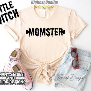 May include: A light beige t-shirt with black dripping text that says "MOMSTER". The shirt is paired with denim shorts and pink Converse shoes.