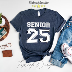 May include: A navy blue t-shirt with white text that says "Senior 25" in a varsity style font.