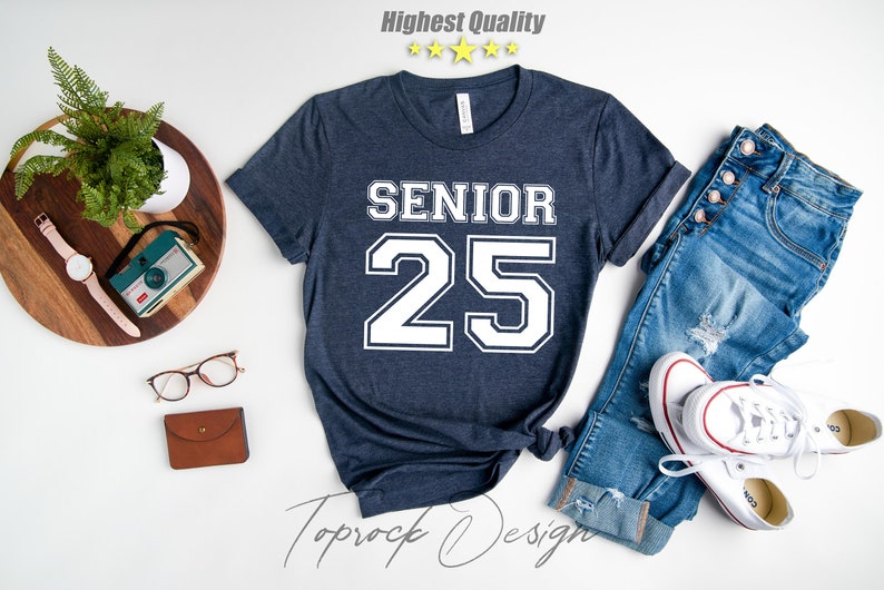 May include: A navy blue t-shirt with white text that says "Senior 25" in a varsity style font.
