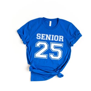 May include: A royal blue t-shirt with white text that reads "Senior 25" in a varsity style font.