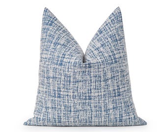 Peut inclure: Un coussin carré présentant un motif texturé à hachures croisées dans des tons de bleu et de blanc cassé. Le tissu affiche un aspect tissé dense avec des lignes entrecroisées qui créent un effet visuel en grille sur toute la surface.