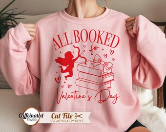 May include: Pink sweatshirt with the text "ALL BOOKED for Valentine's Day" in red. The design includes a silhouette of Cupid with a bow and arrow, books, and hearts. The sweatshirt is a long-sleeved crew neck.