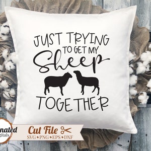 May include: White pillow with black text that reads "Just trying to get my sheep together". Two black sheep silhouettes are shown on either side of the text.