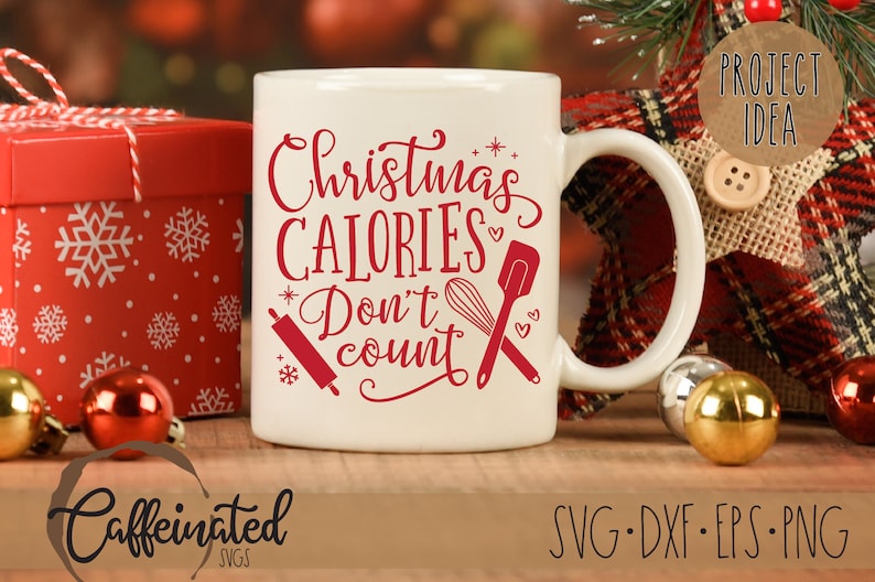 Pu&ograve; includere: Una tazza di ceramica bianca con la scritta "Christmas Calories Don't Count" in rosso. La tazza presenta illustrazioni di un mattarello, una frusta e una spatola. Una scatola regalo rossa e ornamenti sono sullo sfondo.