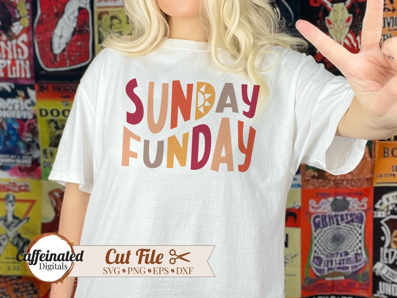May include: White t-shirt with the text "SUNDAY FUNDAY" in colorful, stylized letters. The letters are in shades of orange, red, brown, and yellow.