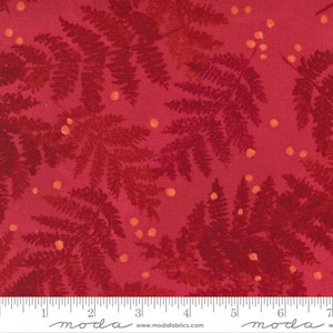 May include: Red fabric with a repeating pattern of fern leaves and small orange dots. The fabric is marked with a ruler and the words "moda" and "www.modafabrics.com".