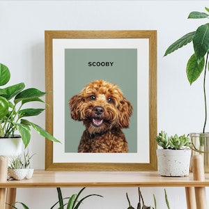 The pet dog portrait is set against a sage green background, allowing Scooby, the Cockapoo, to stand out prominently. Above the image, the name SCOOBY is written in a bold, black font, adding a touch of personalisation to the wall art.
