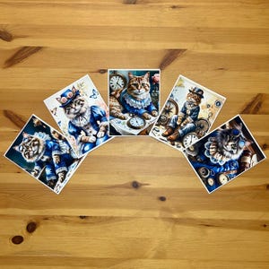 May include: Five art prints featuring steampunk-themed cats. Each print showcases a cat in elaborate attire, including hats, goggles, and Victorian-era clothing. The cats are surrounded by clocks, compasses, and other vintage elements, set against a dark blue background.