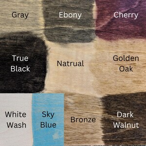 Może przedstawiać: Wzornik bejcy do drewna zawierający dziesięć pr&oacute;bek z etykietami Gray, Ebony, Cherry, True Black, Natrual, Golden Oak, White Wash, Sky Blue, Bronze oraz Dark Walnut. Każda pr&oacute;bka prezentuje unikalną strukturę słoj&oacute;w drewna i wykończenie.