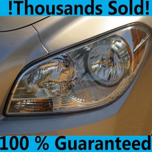 Peut inclure: Gros plan sur un phare de voiture argenté avec un verre transparent et un clignotant jaune. Le texte "!Thousands Sold!" est au-dessus de l'image et "100% Guaranteed" est en dessous de l'image.