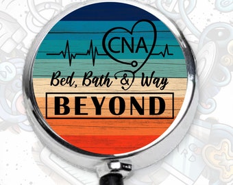May include: A silver retractable badge reel with a round, colorful design. The design features a woodgrain pattern in shades of blue, teal, orange, and red. The text "CNA Bed, Bath & Way BEYOND" is printed in black on the design.
