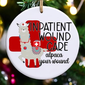 May include: A white ceramic ornament with a red cross and a cartoon alpaca wearing a nurse's hat and stethoscope. The text reads "Inpatient Wound Care alpaca your wound".