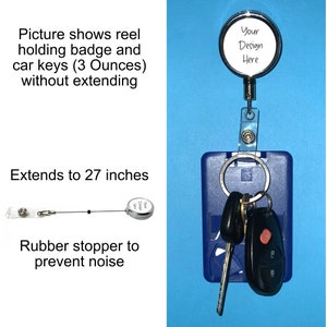 May include: A silver retractable badge reel with a clear plastic badge holder. The reel is extended to show a black cord and a silver round badge holder with the text "Your Design Here". The badge holder is attached to a blue plastic card holder with a clear plastic window. Three keys are attached to the card holder. The reel is on a blue background.