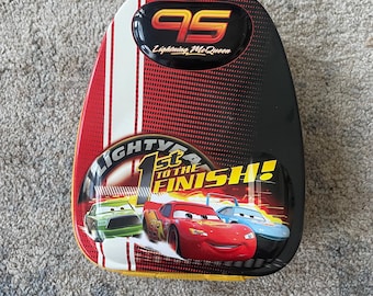 A tin lunchbox or backpack featuring Lightning McQueen from Disney Pixar's "Cars