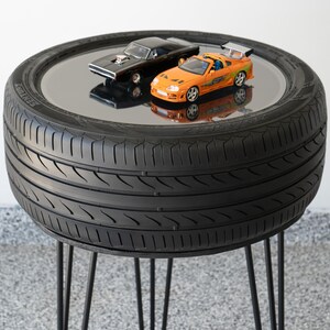 Bar-height tire table crafted from a real recycled tire, featuring a flush plexiglass top, solid wood base, and sturdy 24-inch metal legs, standing at 34 inches tall. This unique automotive table adds an industrial, modern touch to garages, man caves, bars, or home decor. Perfect as a high-top table, side table, or statement piece, it blends durability and style, making it a must-have for car lovers and those who appreciate repurposed furniture.