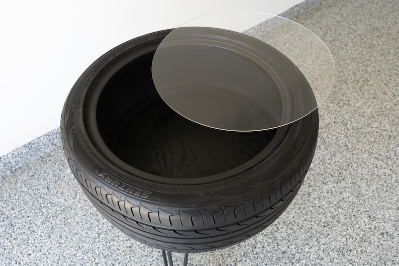 Bar-height tire table crafted from a real recycled tire, featuring a flush plexiglass top, solid wood base, and sturdy 24-inch metal legs, standing at 34 inches tall. This unique automotive table adds an industrial, modern touch to garages, man caves, bars, or home decor. Perfect as a high-top table, side table, or statement piece, it blends durability and style, making it a must-have for car lovers and those who appreciate repurposed furniture.