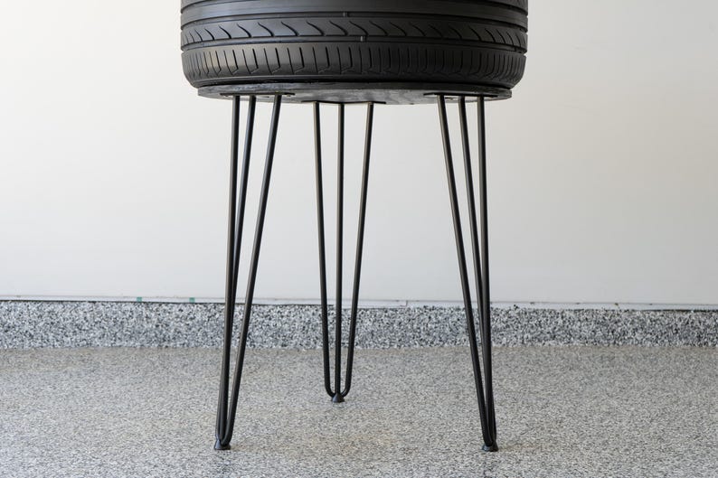 Bar-height tire table crafted from a real recycled tire, featuring a flush plexiglass top, solid wood base, and sturdy 24-inch metal legs, standing at 34 inches tall. This unique automotive table adds an industrial, modern touch to garages, man caves, bars, or home decor. Perfect as a high-top table, side table, or statement piece, it blends durability and style, making it a must-have for car lovers and those who appreciate repurposed furniture.