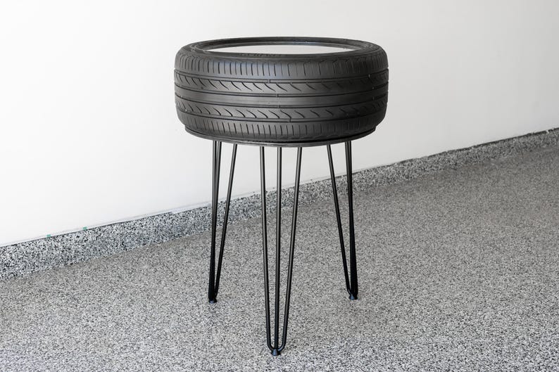 Bar-height tire table crafted from a real recycled tire, featuring a flush plexiglass top, solid wood base, and sturdy 24-inch metal legs, standing at 34 inches tall. This unique automotive table adds an industrial, modern touch to garages, man caves, bars, or home decor. Perfect as a high-top table, side table, or statement piece, it blends durability and style, making it a must-have for car lovers and those who appreciate repurposed furniture.