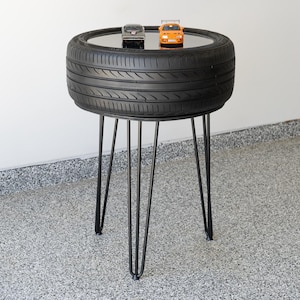 Bar-height tire table crafted from a real recycled tire, featuring a flush plexiglass top, solid wood base, and sturdy 24-inch metal legs, standing at 34 inches tall. This unique automotive table adds an industrial, modern touch to garages, man caves, bars, or home decor. Perfect as a high-top table, side table, or statement piece, it blends durability and style, making it a must-have for car lovers and those who appreciate repurposed furniture.