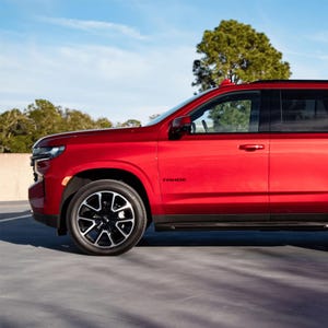 May include: A red Chevrolet Tahoe SUV with black wheels and a floral design on the rear window.