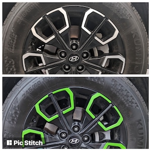 May include: A close-up of a black car wheel with a silver rim. The wheel has a green accent around the spokes. The tire is a Kumho Solus TA31 245/60 R18.