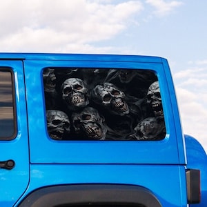 May include: A blue Jeep Wrangler with a skull decal on the back window. The decal features multiple skulls in black and white.