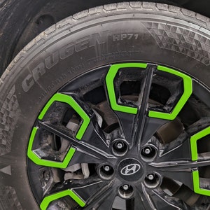 May include: Black car tire with a green rim and the words "Crugen HP71" on the sidewall.