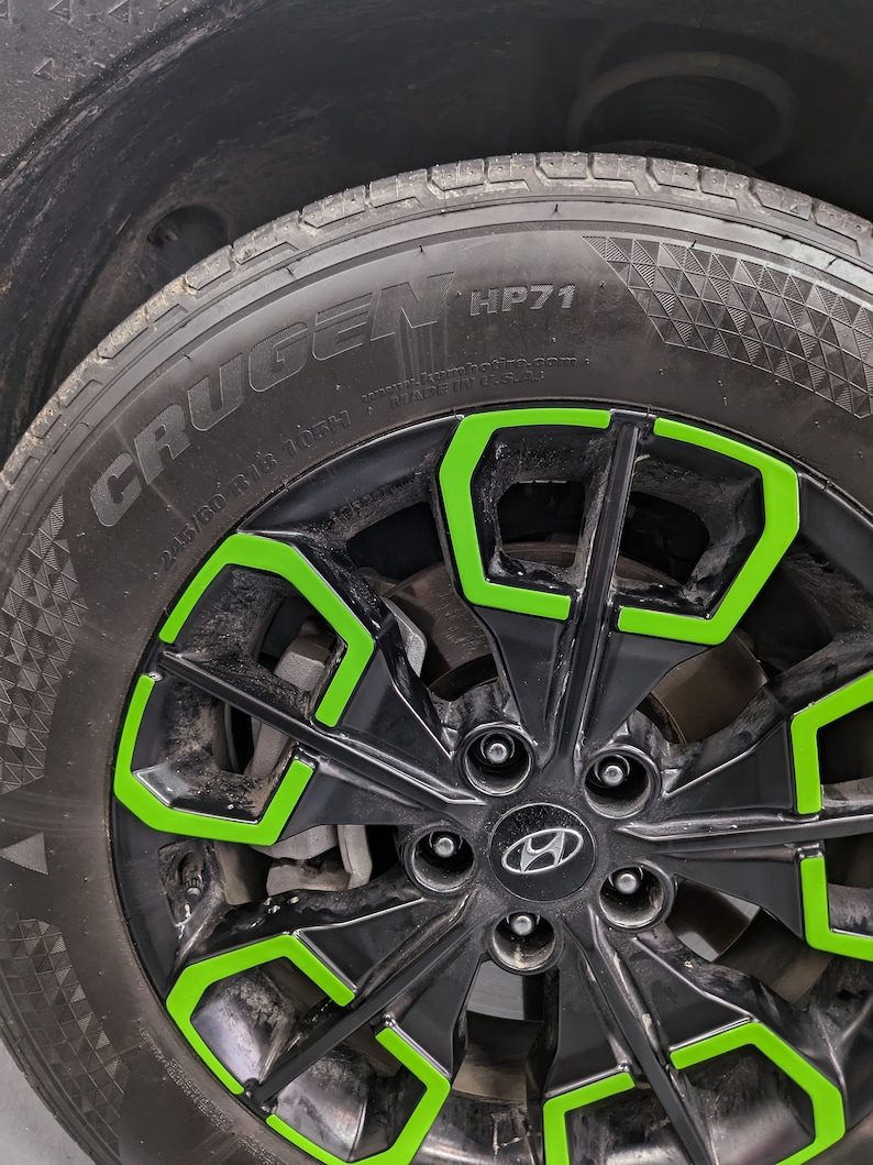 May include: Black car tire with a green rim and the words "Crugen HP71" on the sidewall.