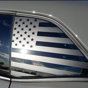 May include: A black and white American flag decal on a car window. The flag is in the style of a window tint.