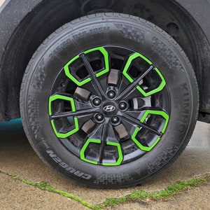 May include: A black car tire with a green rim and the words "CRUGEN HP71" and "KUMHO" printed on the side. The tire size is 245/60 R18-105H.