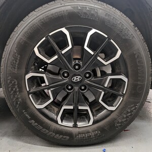 May include: A black tire with a silver rim and the text "KUMHO CRUGEN HP71 245/60 R18 105H" on the side.