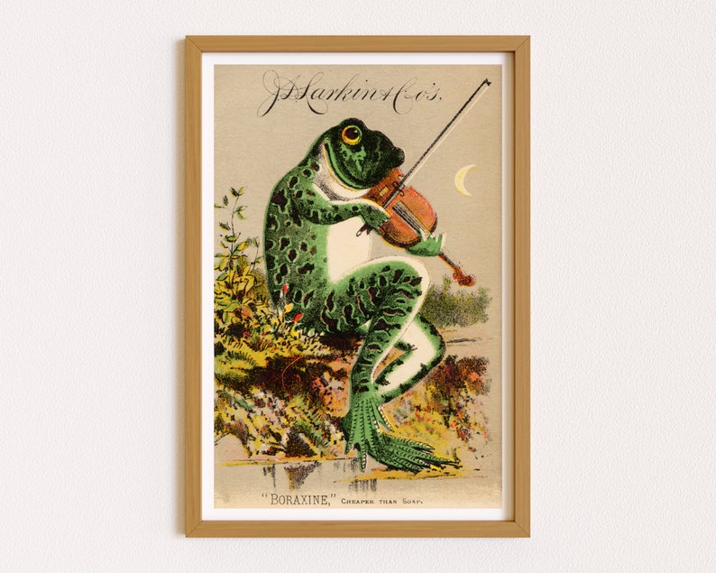 Puede incluir: Anuncio vintage enmarcado que muestra una rana verde tocando el viol&iacute;n. La rana tiene un vientre blanco y manchas verde oscuro. El texto en la parte superior dice "J. Harkin & Co.'s" y en la parte inferior "Boraxine, m&aacute;s barato que el jab&oacute;n."