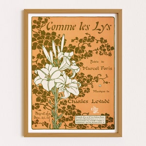 May include: A framed vintage art print featuring a floral design with the text "Comme les Lys." The artwork showcases white lilies and green foliage against an orange background. The print includes text indicating the poem's author, the composer, and the publisher.