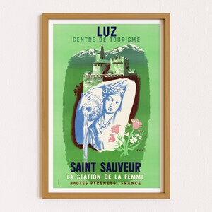 Op de afbeelding: Een vintage reisposter die reclame maakt voor Saint Sauveur, een vakantiebestemming in de regio Hautes-Pyr&eacute;n&eacute;es in Frankrijk. De poster heeft een groene achtergrond met een kasteel in de verte, een vrouw die water uit een kan giet en de tekst "Luz Centre de Tourisme" en "Saint Sauveur La Station de la Femme Hautes Pyr&eacute;n&eacute;es. France".