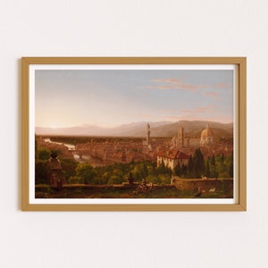 May include: A framed painting depicting a panoramic view of Florence, Italy. The painting shows the city from a distance, with the Arno River winding through the cityscape. The iconic Duomo, with its distinctive dome, is prominently featured in the background. The foreground features a group of figures enjoying the view from a hilltop.