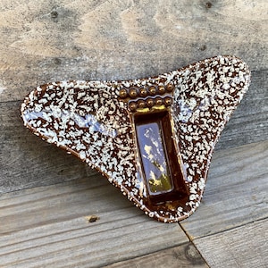 May include: A rustic wooden sign with the text "Welcome" in a handwritten style. The sign is painted white with a distressed finish, and features a decorative floral element in the corner. The background is a blurred image of a wooden surface.