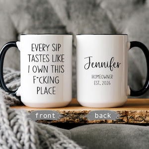 May include: Two white ceramic mugs with black handles and rims. One mug reads "EVERY SIP TASTES LIKE I OWN THIS F*CKING PLACE." The other mug says "Jennifer HOMEOWNER EST. 2026."